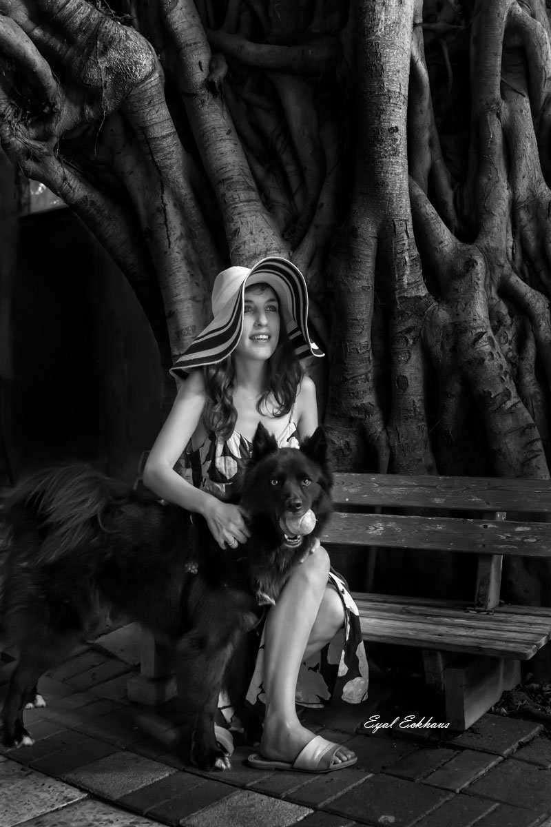 Fashion model and dog gazing with ball in mouth